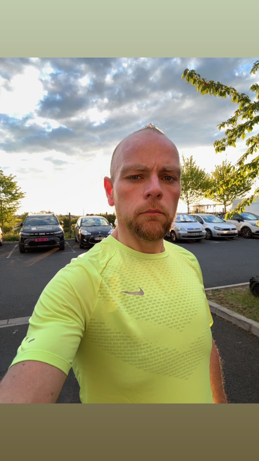 Bruno Mougenot en t-shirt de sport jaune, en extérieur, sous un ciel de fin de journée